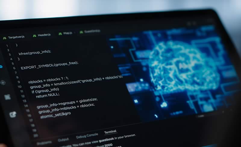 Visualización digital de un cerebro representando inteligencia artificial y computación cuántica sobre una pantalla con código informático